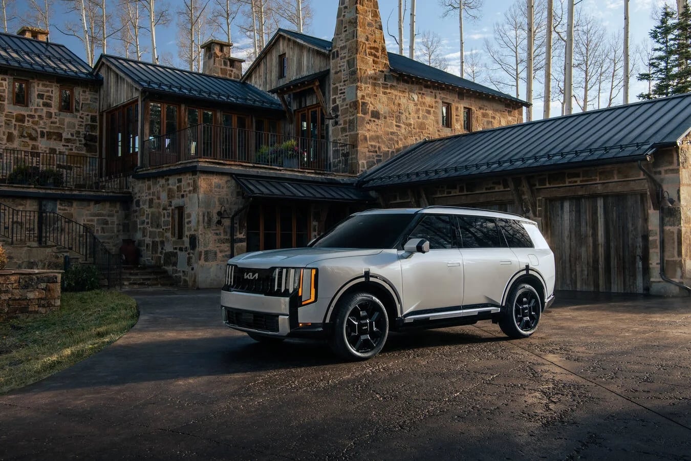 White Kia SUV parked outside a luxury lodge
