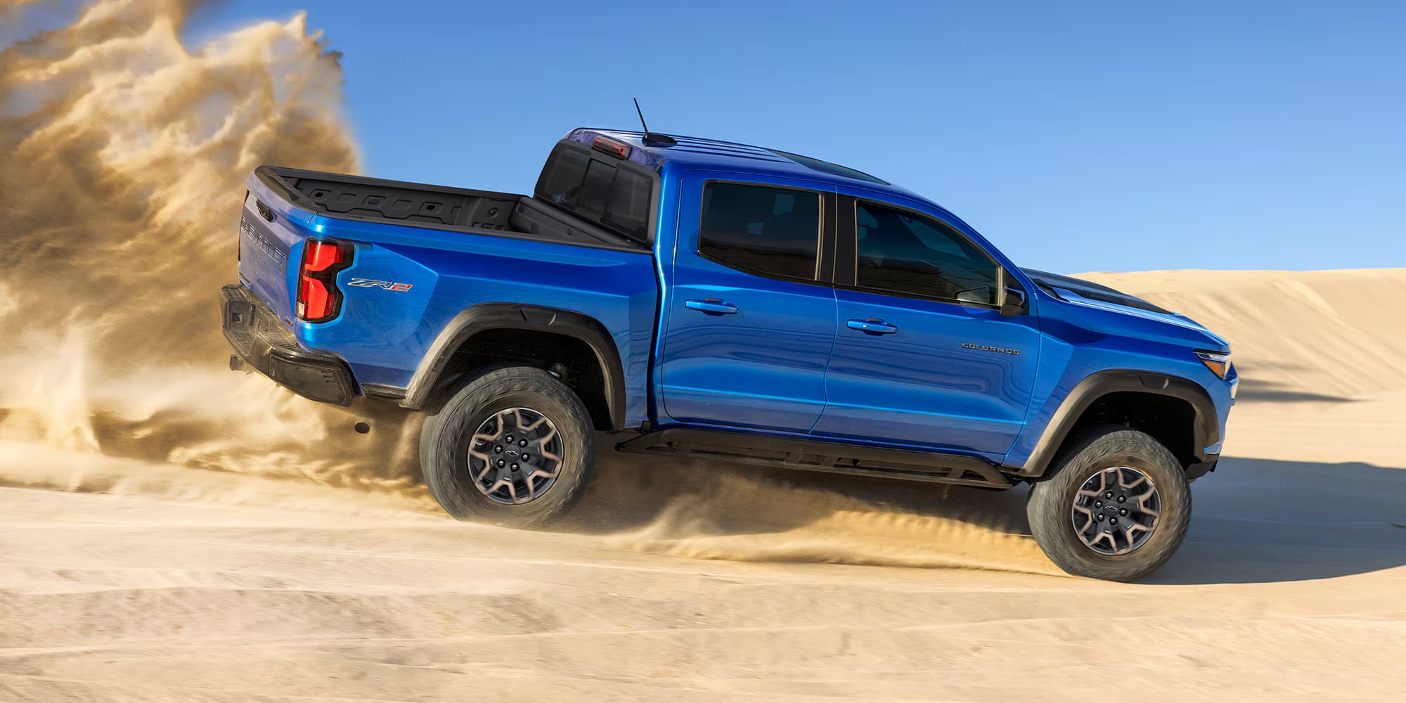 Blue Chevrolet Colorado ZR2 driving through desert sand