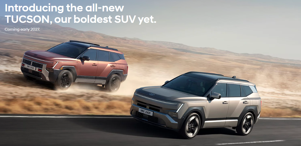 Two boxy Hyundai Tucson SUVs driving through a desert landscape, one on dirt and one on asphalt.