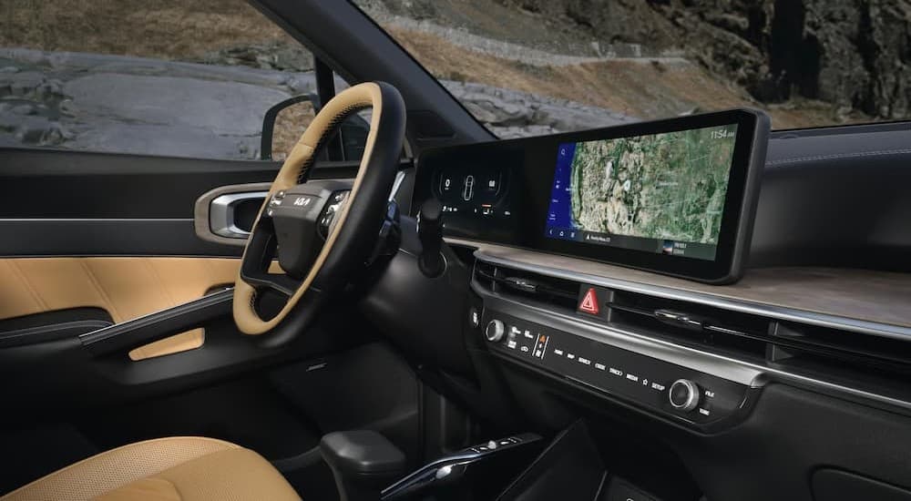 Two-tone Kia Sorento interior with a wide digital display and leather-wrapped steering wheel.