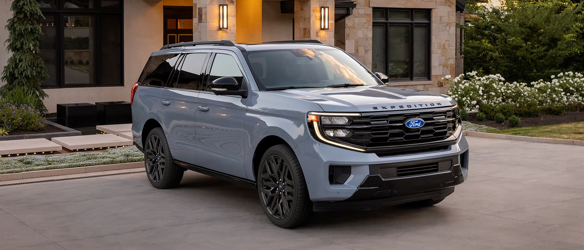 Grey Ford Expedition SUV parked on a residential driveway in front of a modern home.