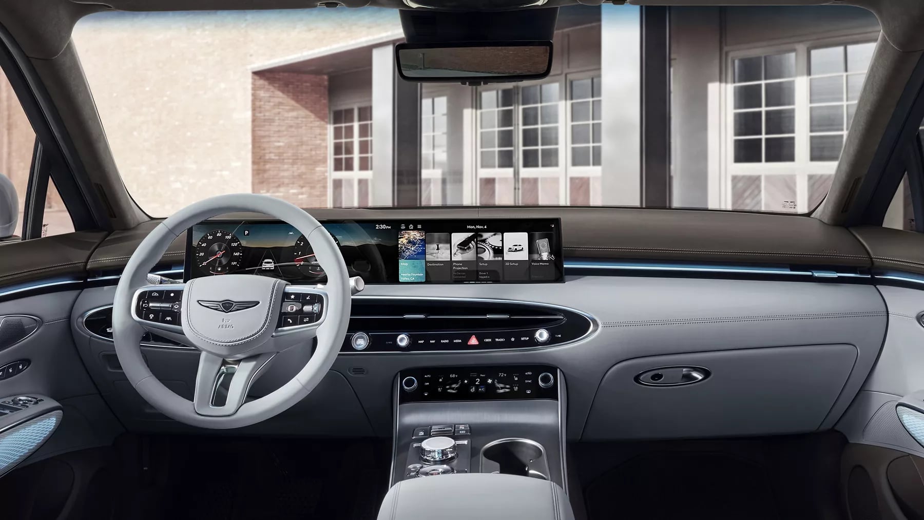 Modern luxury car interior featuring a wide digital dashboard screen, light grey leather trim, and Genesis steering wheel.