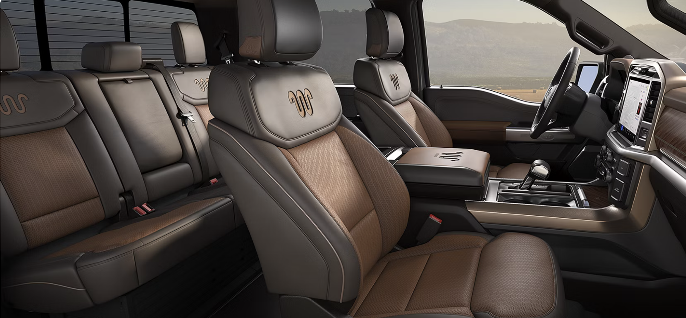 Modern pickup truck interior with luxury brown leather seating, King Ranch logo embroidery, and digital dashboard.