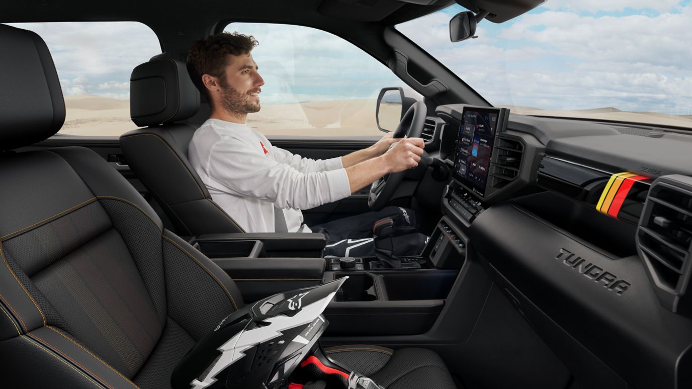 The interior of a Toyota Tundra with a man behind the wheel.