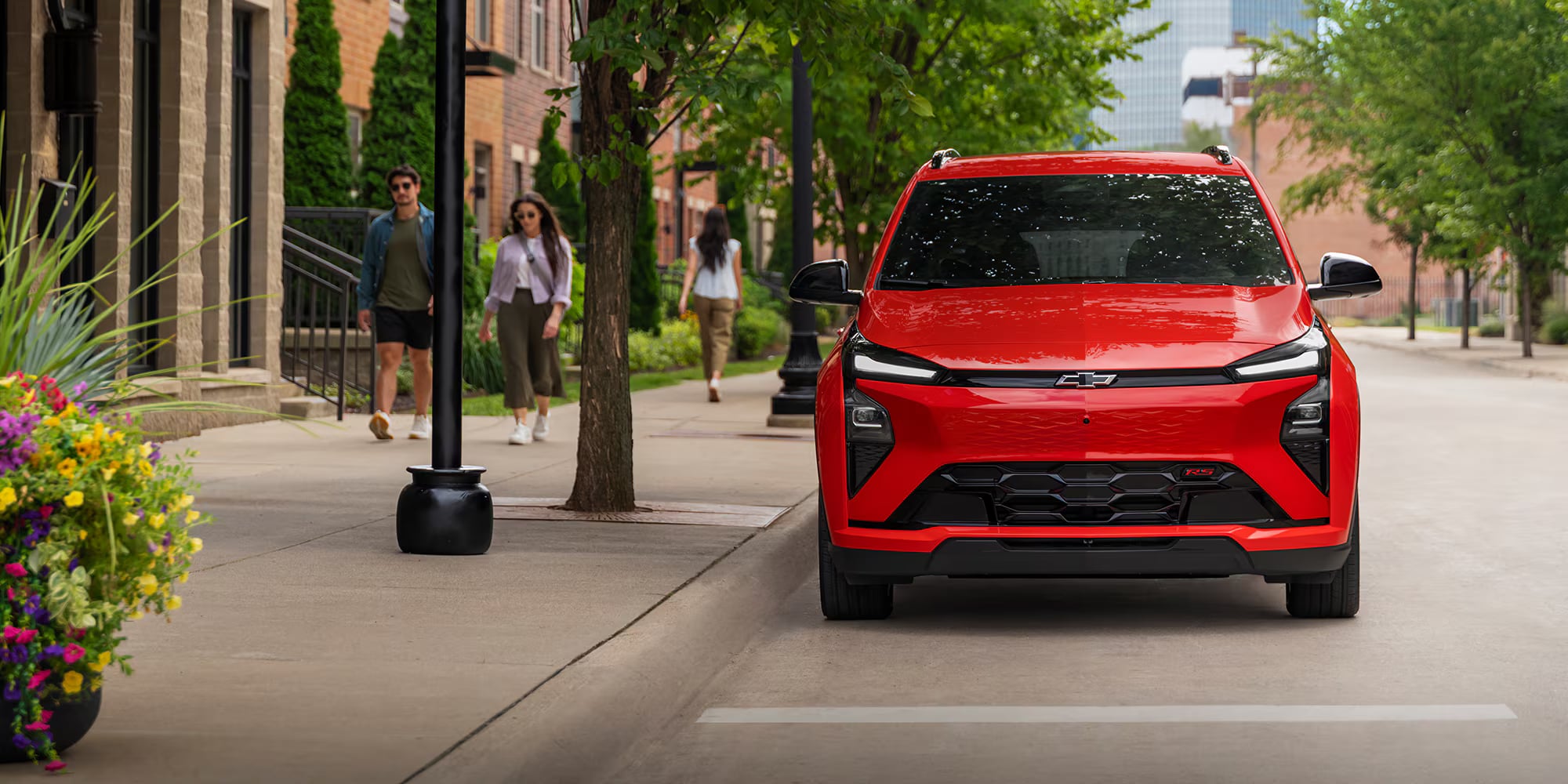 Front view of a red 2027 Chevrolet Bolt on an urban street