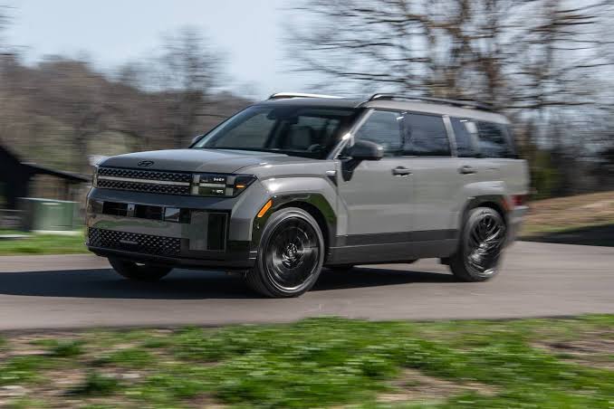Gray Hyundai Santa Fe driving along a paved road