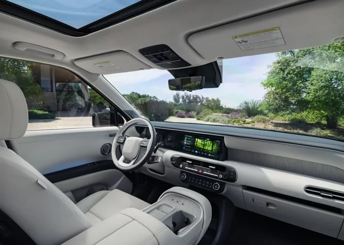 Interior view of a modern SUV featuring light gray leather seats, a digital dashboard display, and a sunroof.
