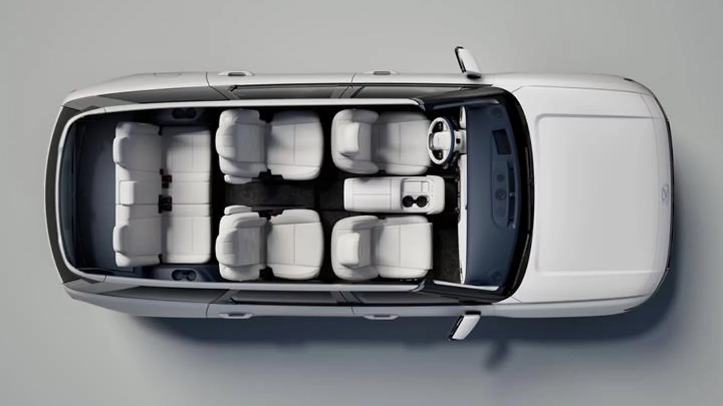 Top-down overhead view of a modern white SUV displaying a seven-passenger three-row white leather interior layout.