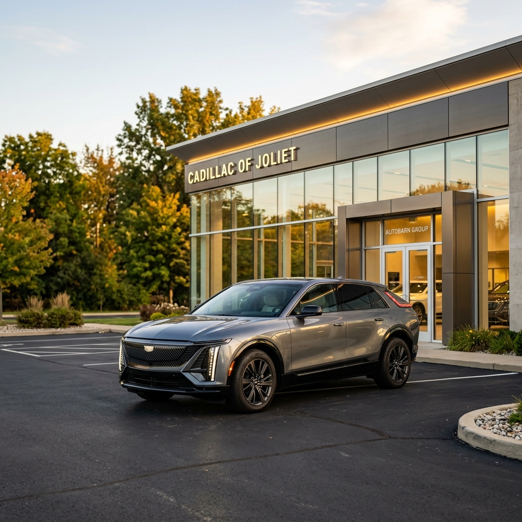 Gray Cadillac Lyriq electric SUV parked outside the modern Cadillac of Joliet dealership building at sunset. (Representative image for illustration purposes only. Actual vehicle may vary based on trim and configuration.)