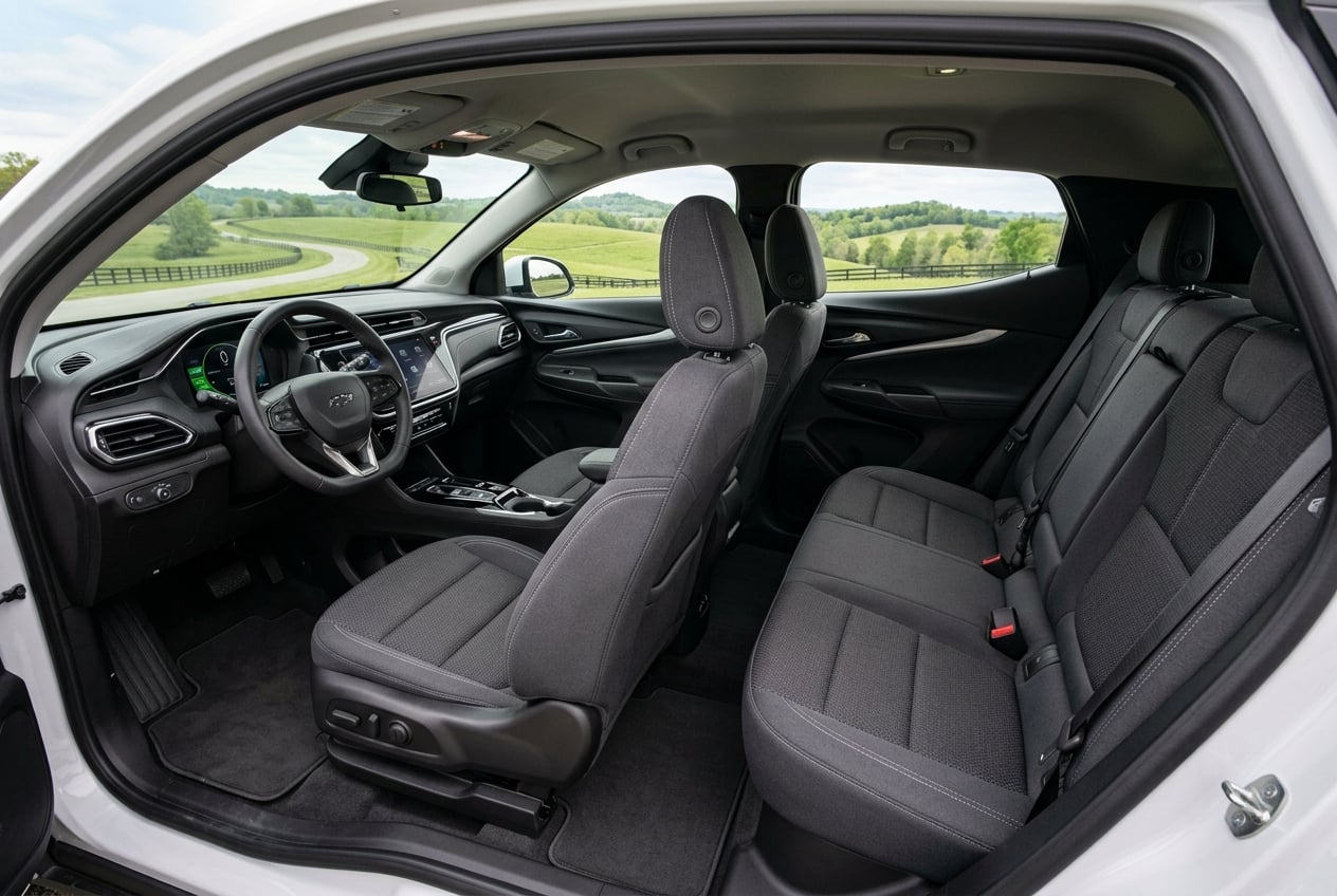 2027 Chevrolet Bolt interior, view from the rear doorway showing comfortable front and rear seats, large center touchscreen and dashboard, soft natural light through the windows with Kentucky countryside visible outside, realistic automotive interior photography, no people, no text or logos (Representative image for illustration purposes only. Actual vehicle may vary based on trim and configuration.)