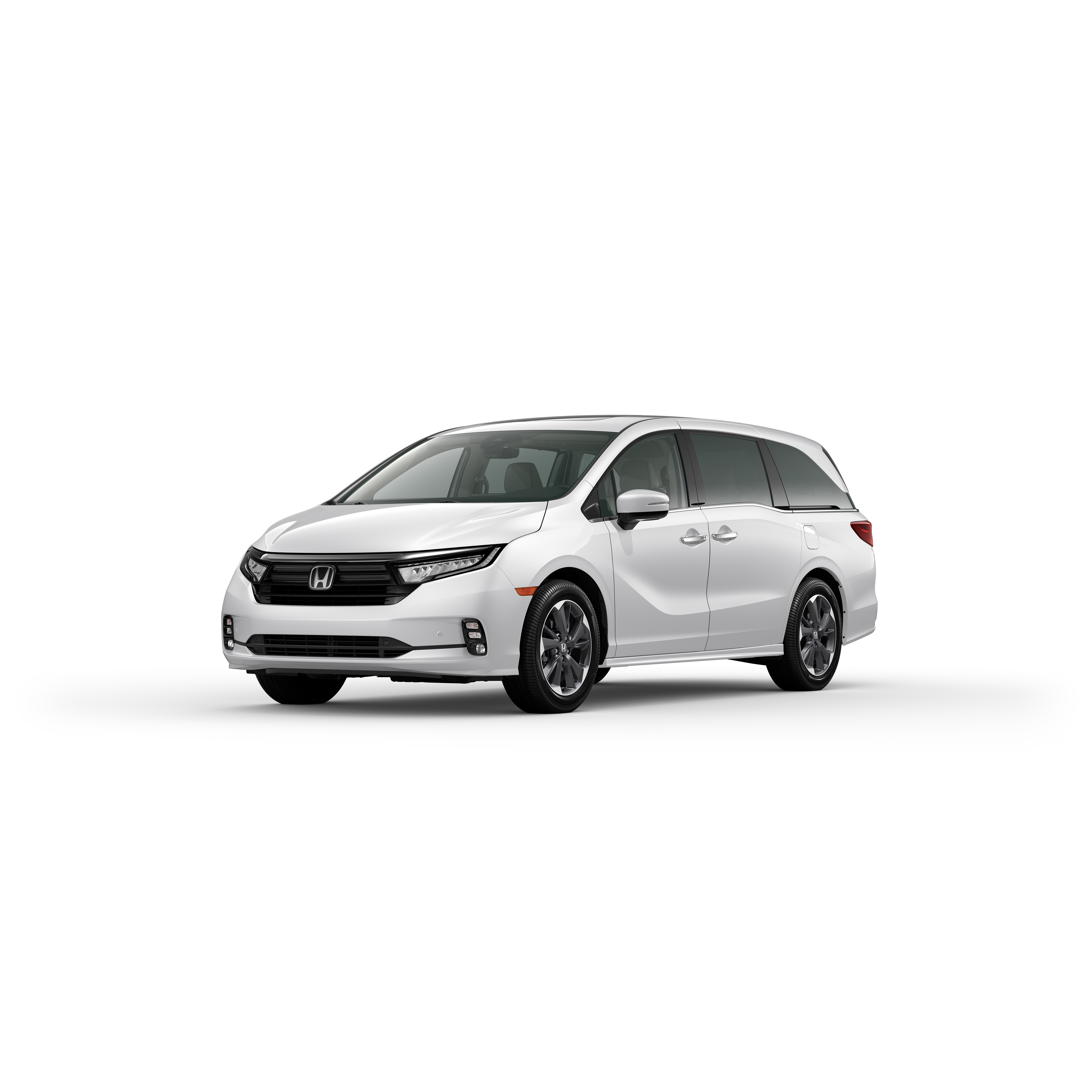 White Honda Odyssey minivan on black background.
