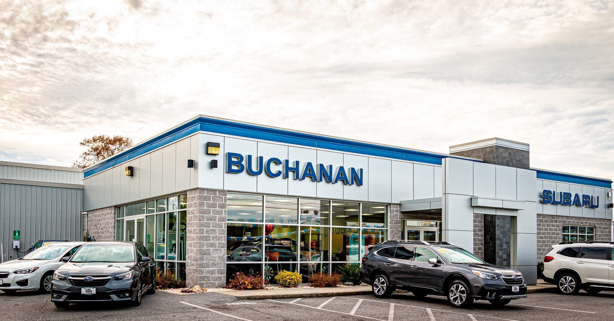 Buchanan Subaru car dealership building exterior with several Subaru vehicles parked in front.