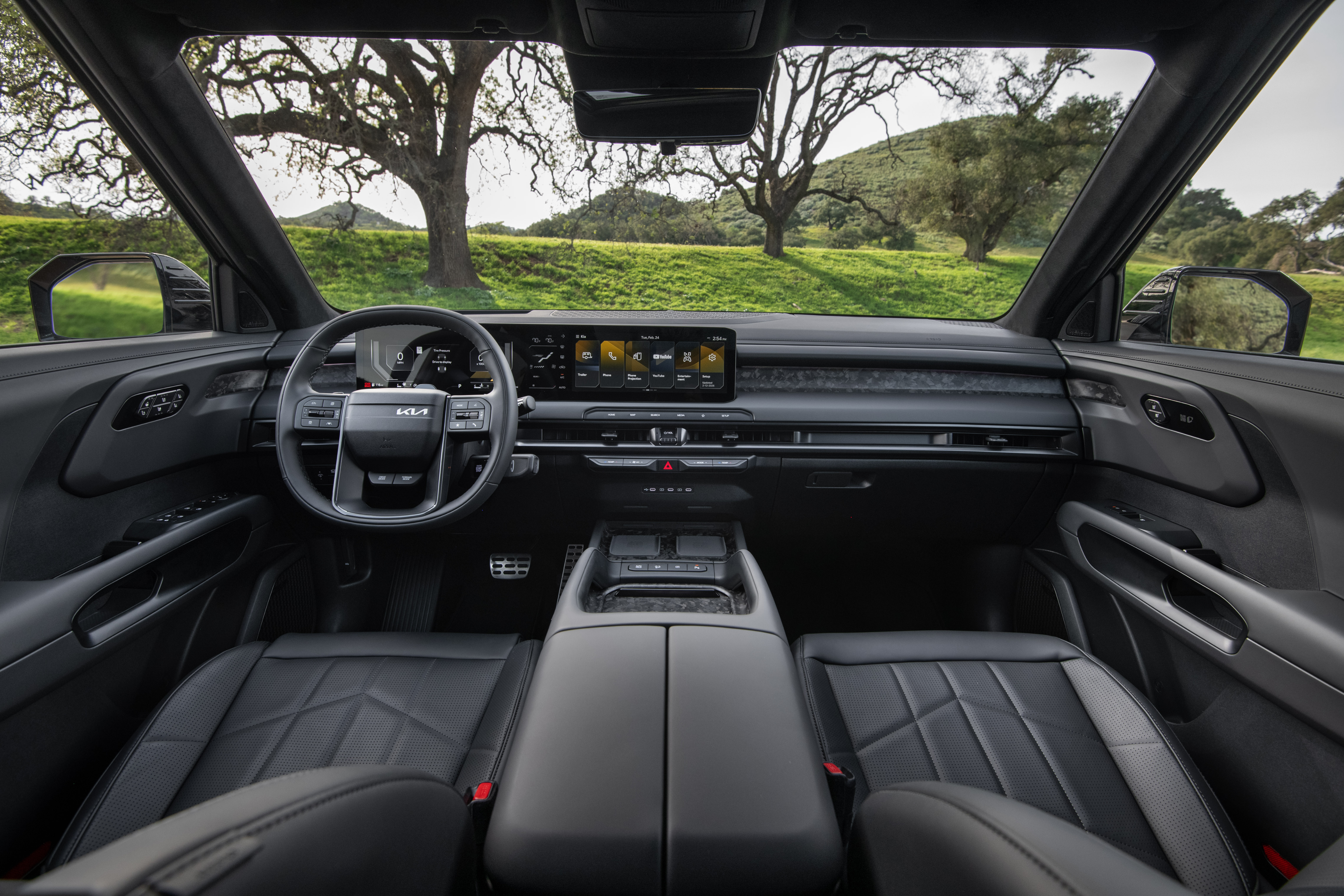 Interior view of a modern Kia EV9 cabin with wide digital displays and a minimalist black design.