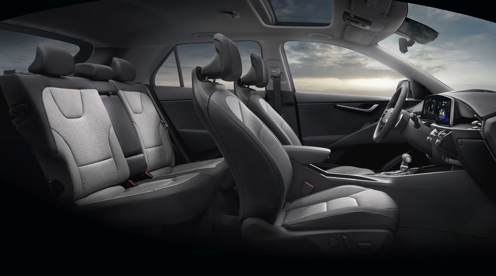 Spacious modern car interior with two-tone black and light gray seats, sunroof, and digital dashboard display.
