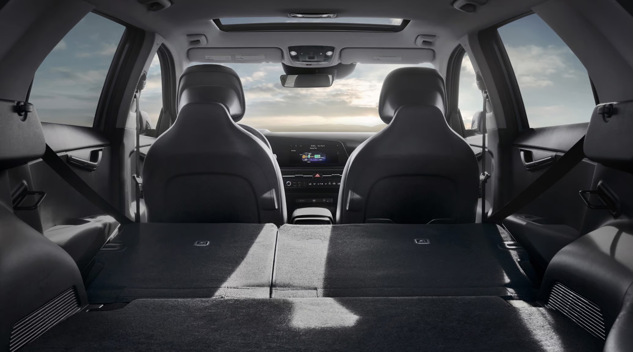 Interior view from the back of a modern SUV looking forward, showing rear seats folded flat to maximize cargo space.
