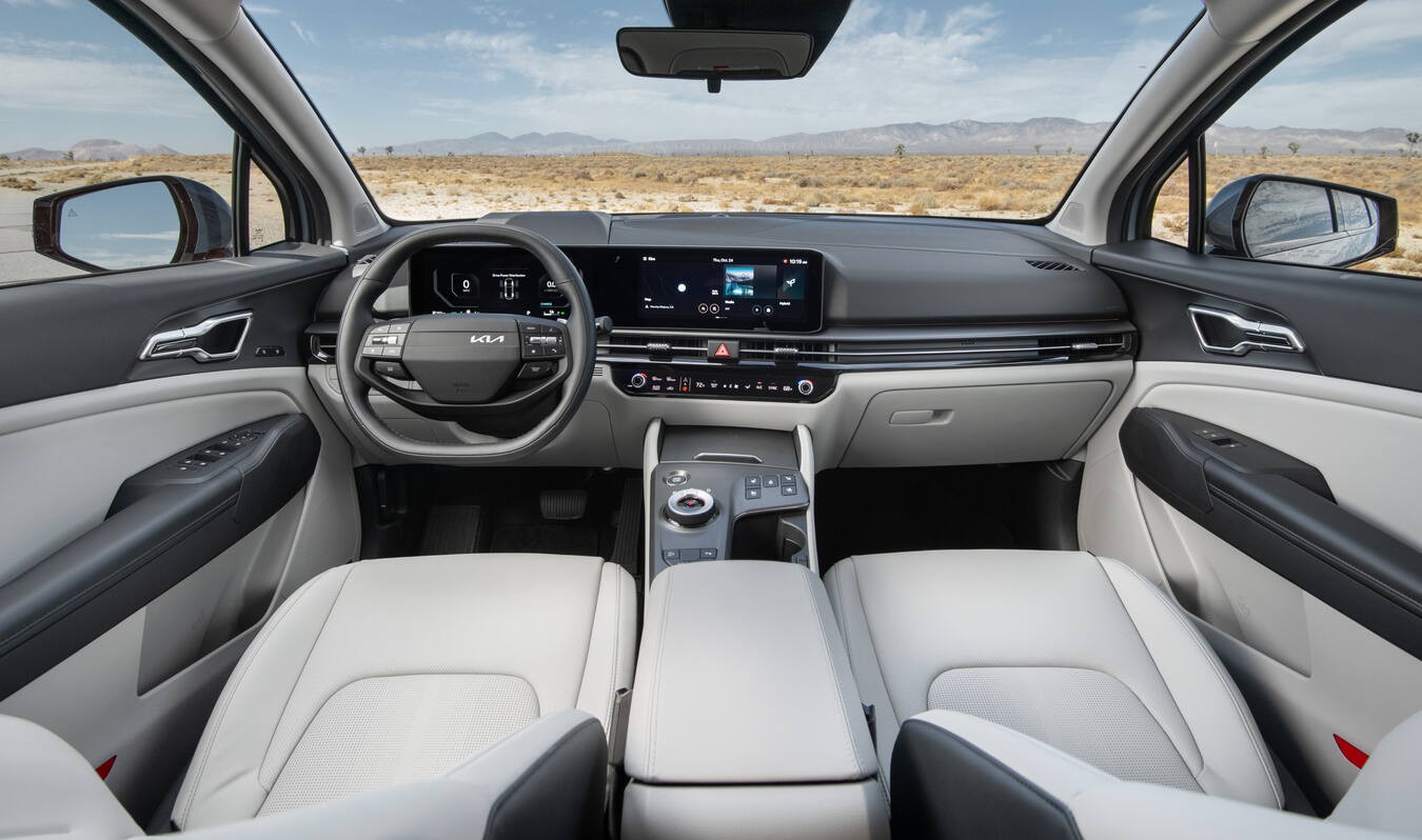 Kia Sportage front cabin with light-colored seats and digital displays.