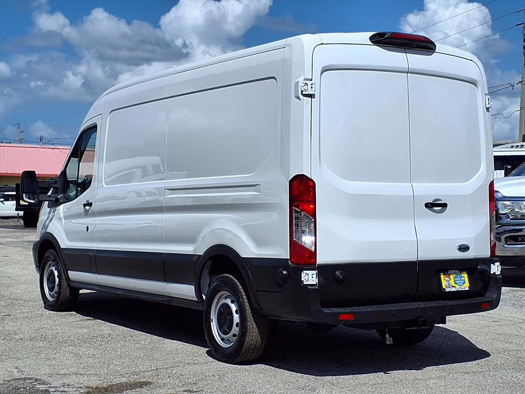 A high-roof Ford Transit cargo van parked in a driveway.
