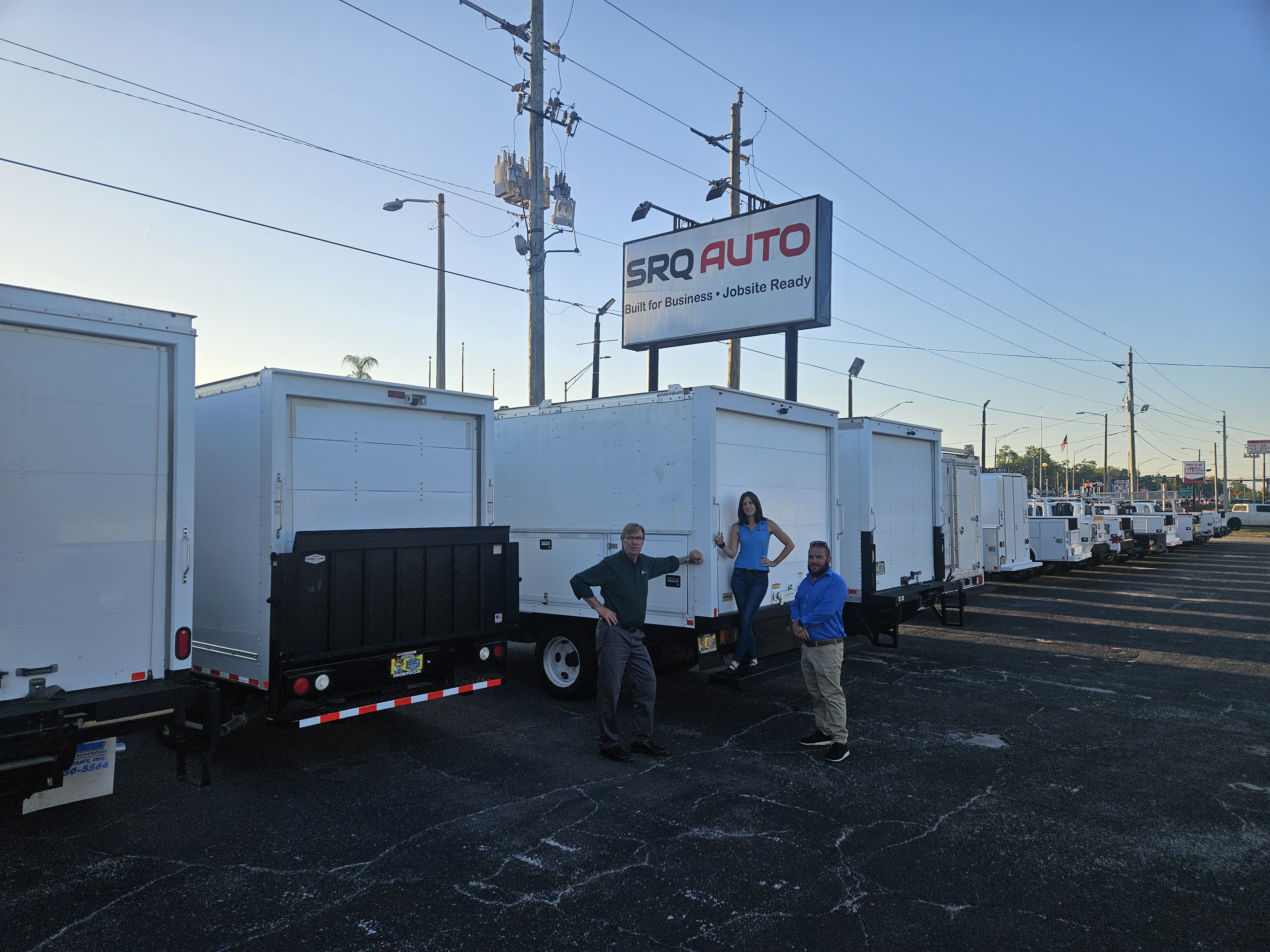 A diverse lineup of commercial trucks and vans parked in front of SRQ Auto LLC in Bradenton, Florida