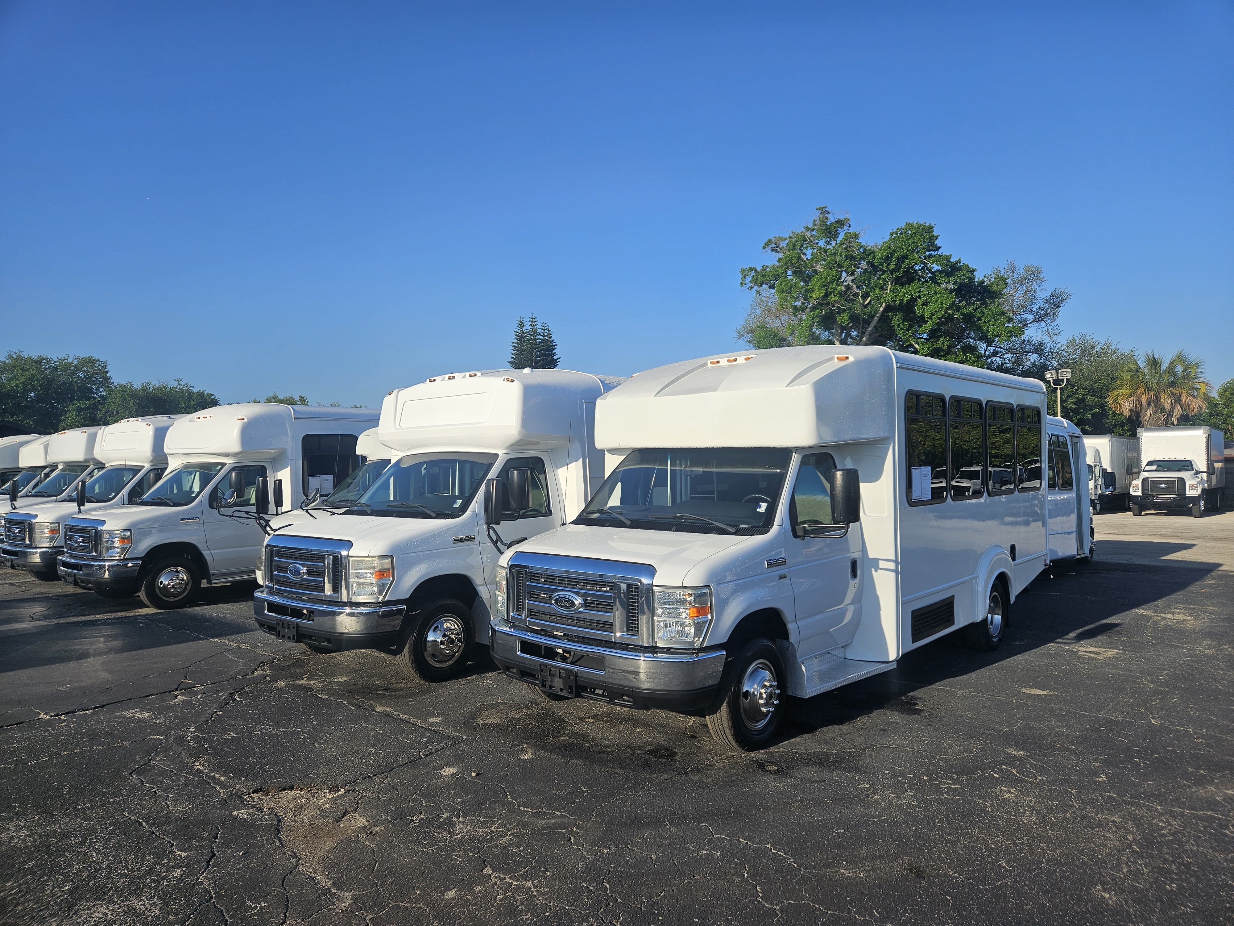 A clean, white late-model shuttle bus parked in the Florida sunshine at SRQ Auto LLC.