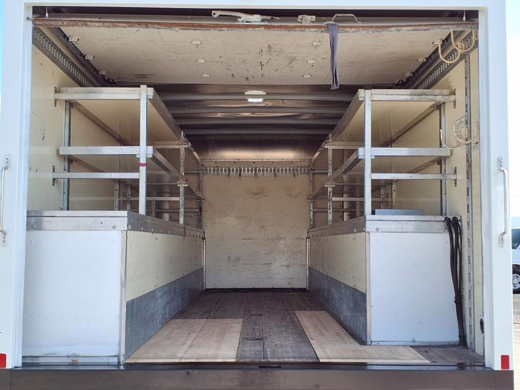 Interior of a cargo van featuring multi-tiered steel shelving units and specialized refrigerant tank racks.