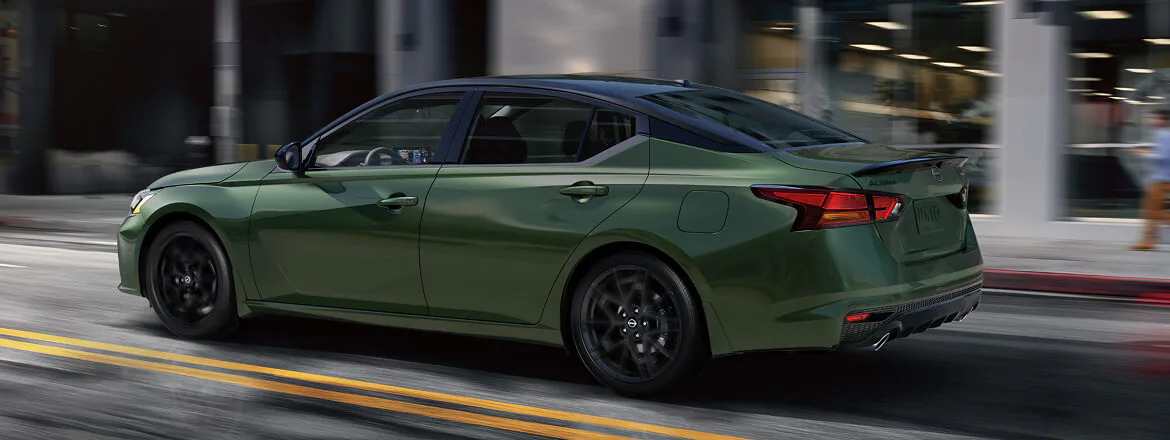The 2026 Nissan Altima confidently navigating a winding, wet road in the foothills of North Carolina