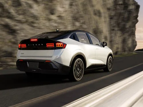 A 2026 Nissan LEAF gliding silently through a scenic neighborhood.