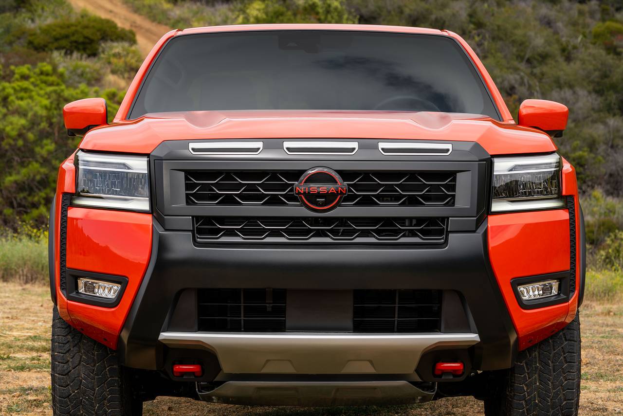 Front view of a vibrant orange Nissan Frontier pickup truck with a black grille and red accents.
