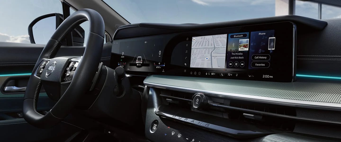 Interior view of a Nissan Murano dashboard featuring a large dual-screen digital display and leather steering wheel.