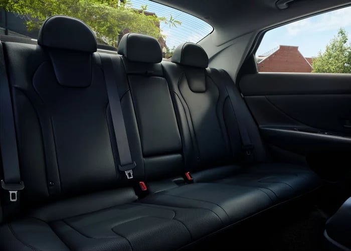 Clean black leather backseats of a modern sedan, viewed from the interior.