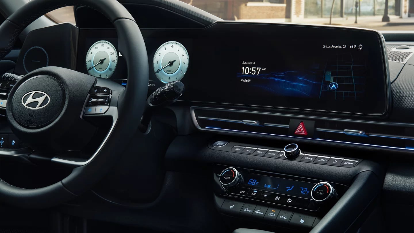 Interior view of a modern Hyundai car showing the steering wheel, digital dashboard, and center touchscreen console.