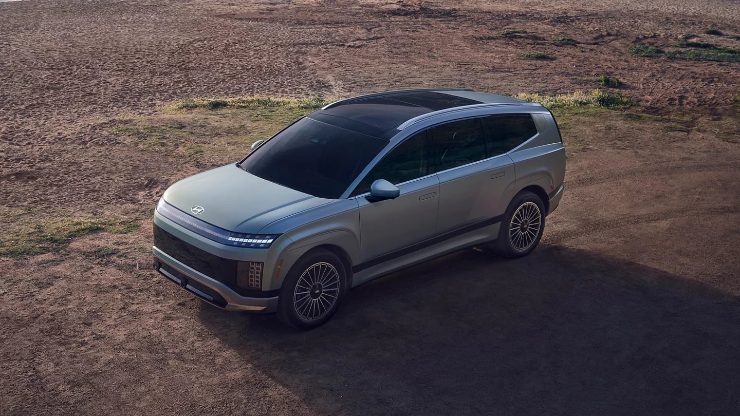 Silver Hyundai IONIQ 9 electric SUV parked on sandy terrain shown from a high angle.