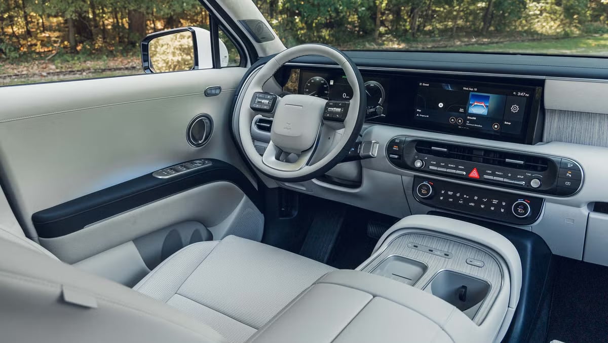 Interior view of a modern SUV featuring a light grey leather seat, two-tone steering wheel, and dual digital screens.