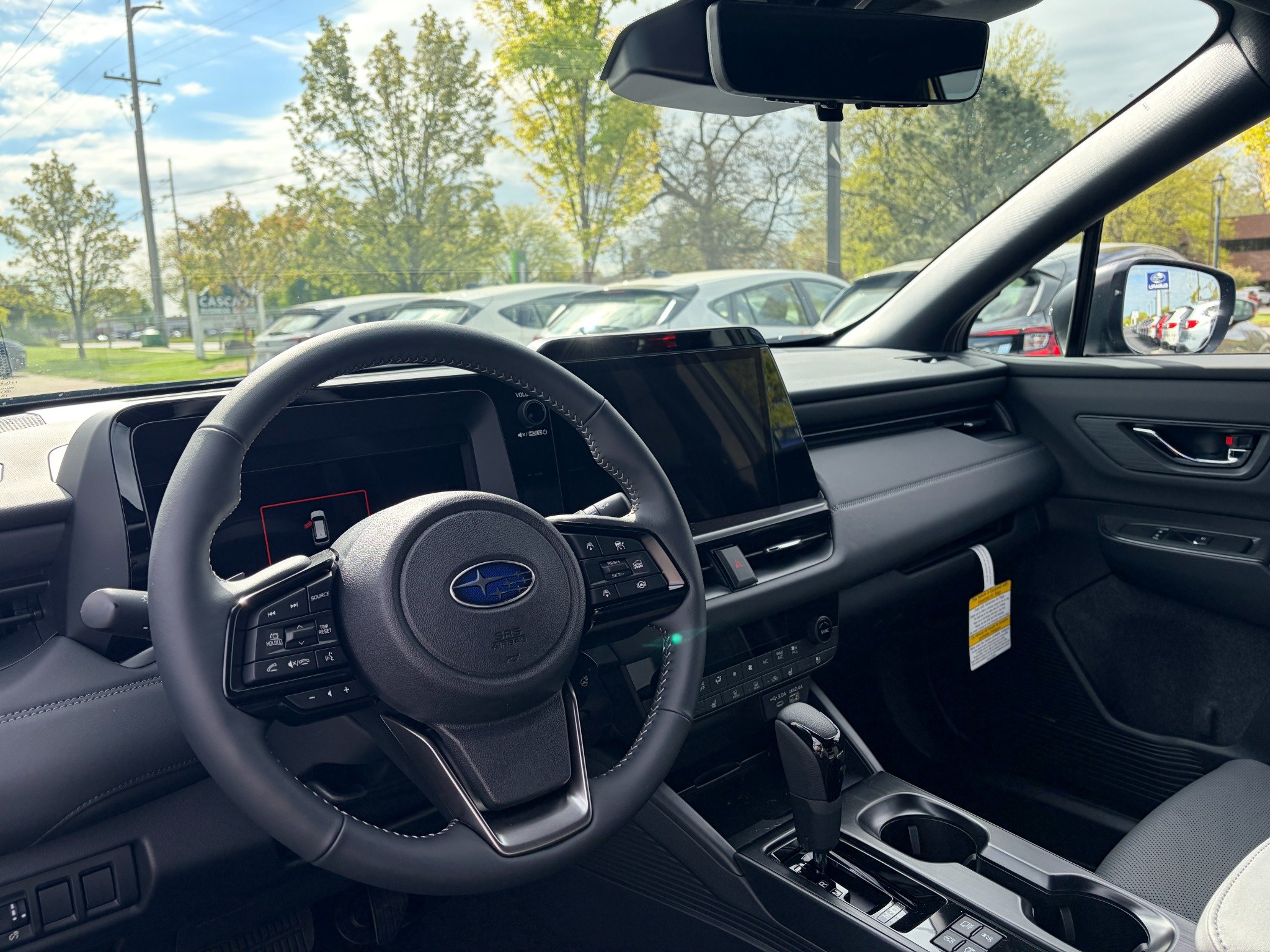 Interior dashboard view of a modern Subaru vehicle showing the steering wheel, infotainment screen, and center console.