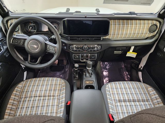 Interior of a modern Jeep Wrangler with distinctive plaid fabric seats and dashboard trim.