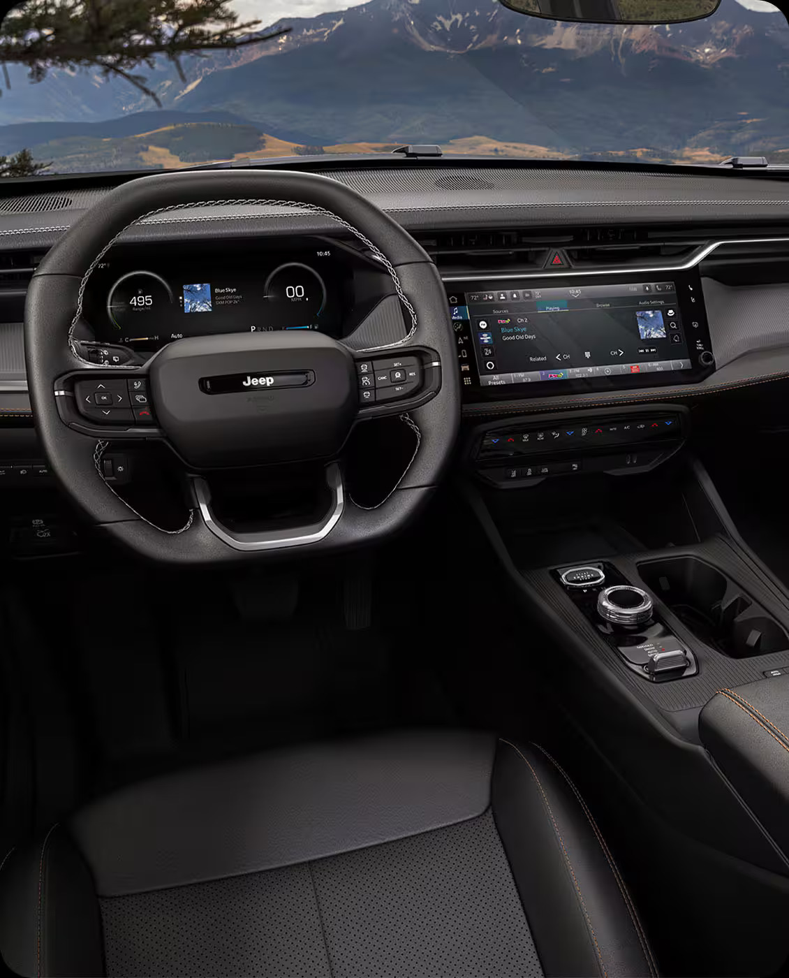 Modern Jeep interior featuring a digital instrument cluster, touchscreen infotainment system, and scenic mountain view.
