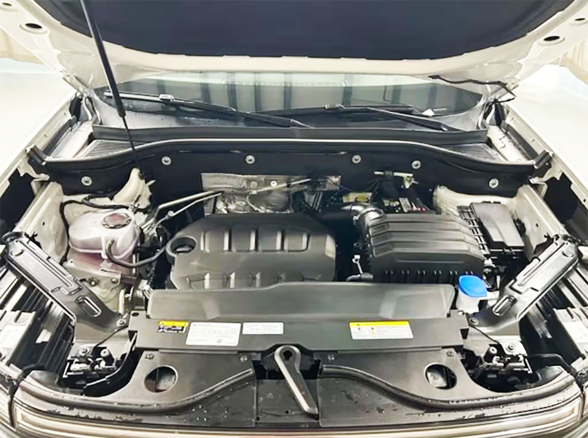 Close-up of a VW Atlas Cross Sport car engine bay showcasing the motor and various components.