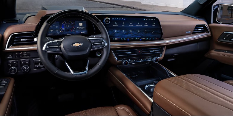 Dashboard and steering wheel of a modern Chevrolet vehicle featuring premium brown leather and large digital screens.