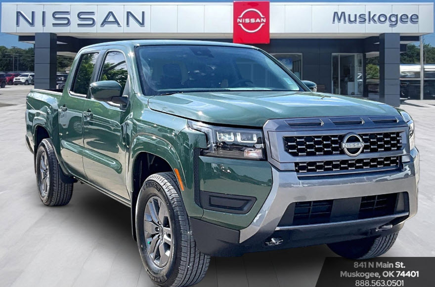 A green Nissan Frontier parked in front of a Nissan Muskogee dealership.