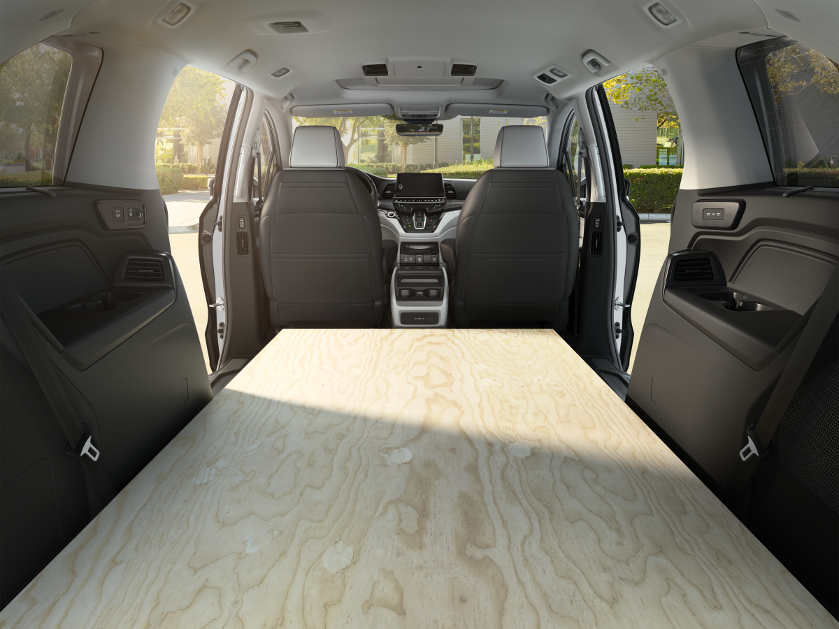 Inside a minivan showing a wooden platform in the cargo area.