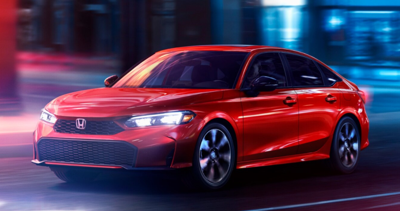 2026 Honda Civic driving on a city street at night.