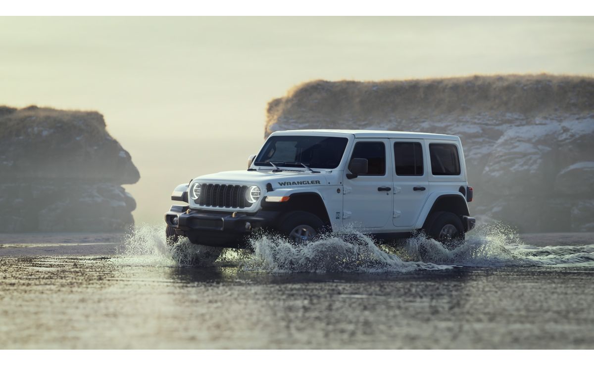 White Jeep Wrangler navigates shallow water with rock formations in the background, creating a sense of adventure.