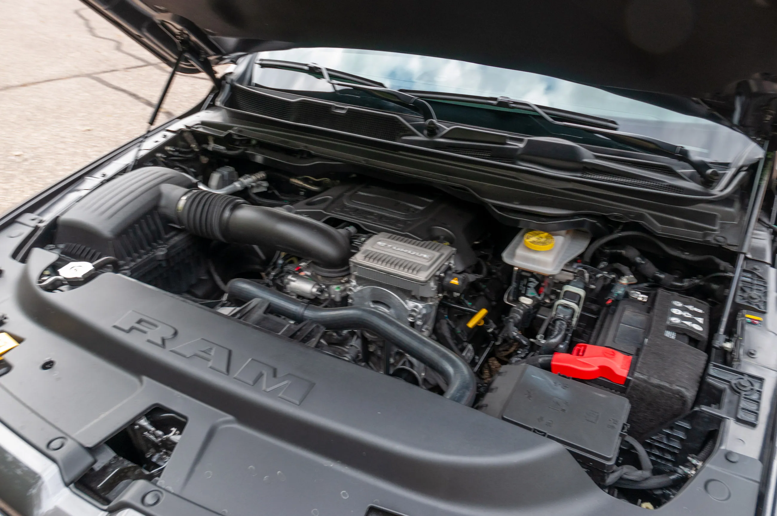 Engine compartment of a black RAM truck with the hood open.