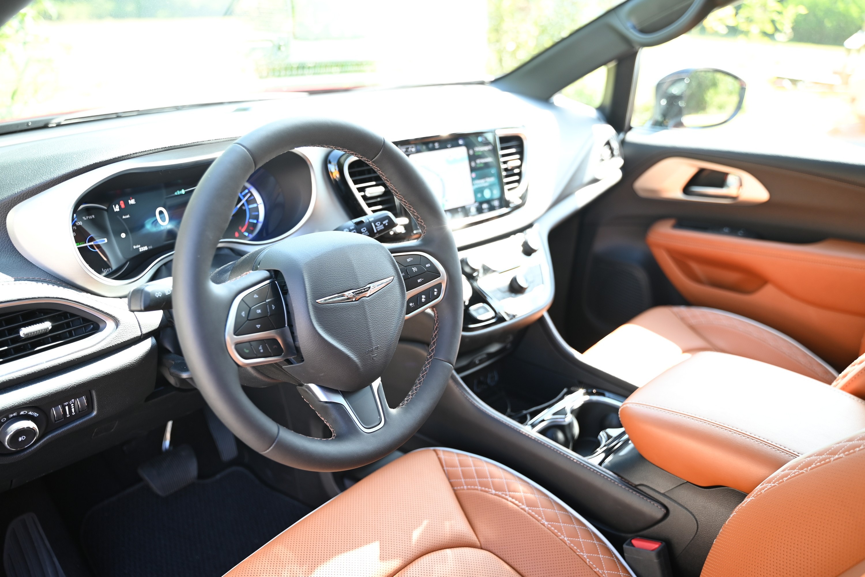 Car interior with brown leather seats and black dashboard.