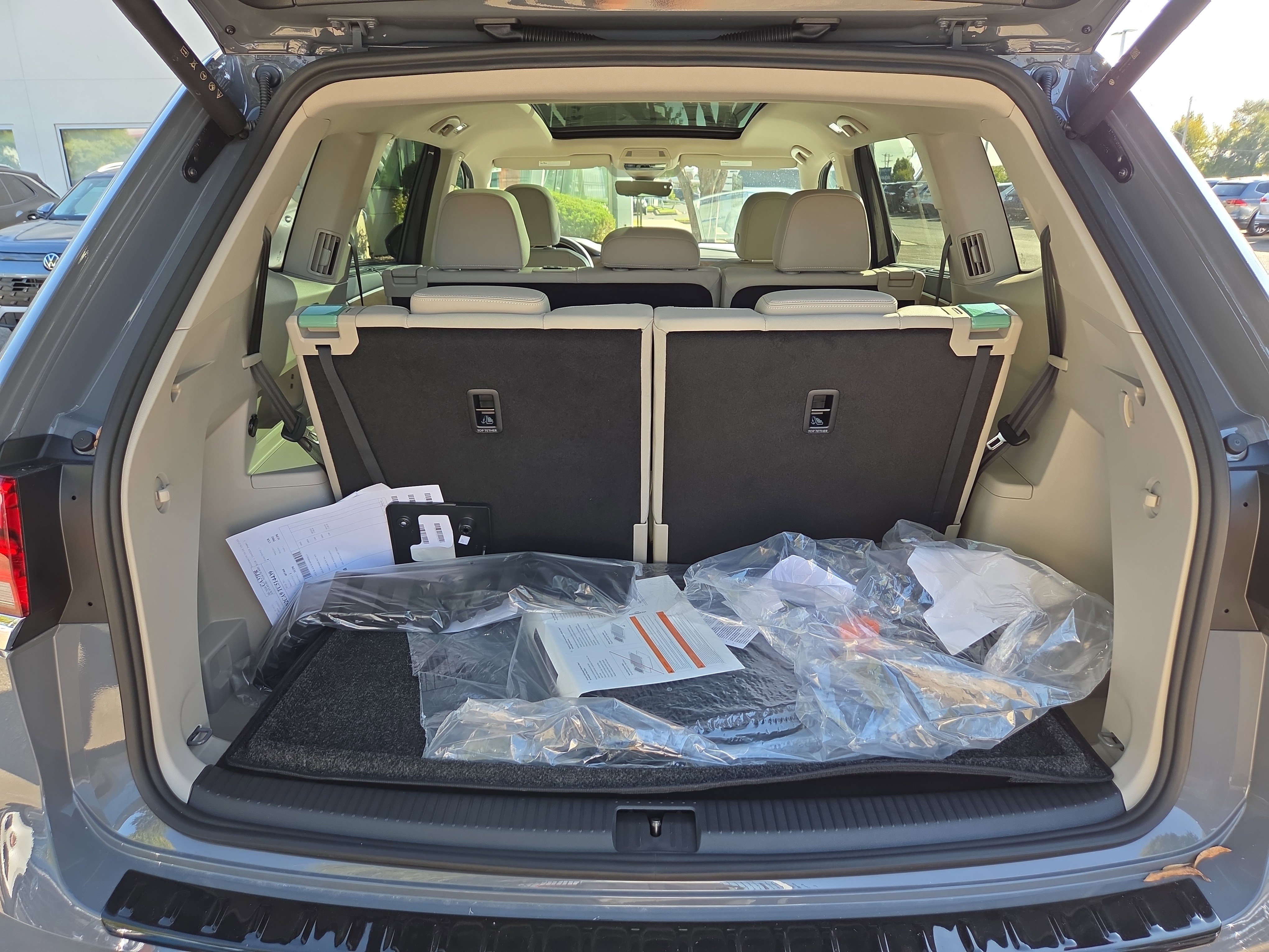 Open trunk of gray SUV with seats folded down, showing cargo space.