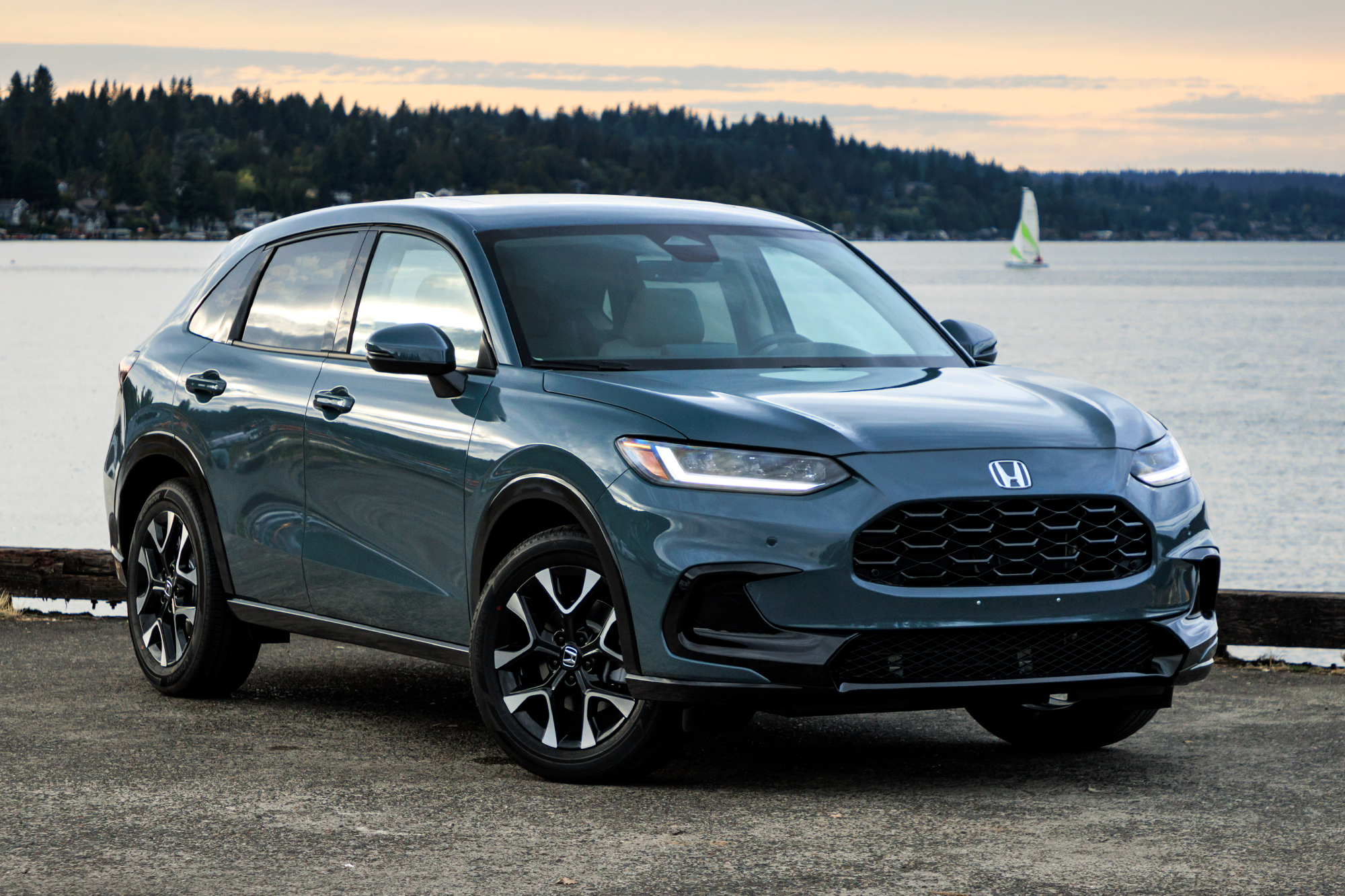 Blue 2023 Honda HR-V SUV parked near a lake at sunset.