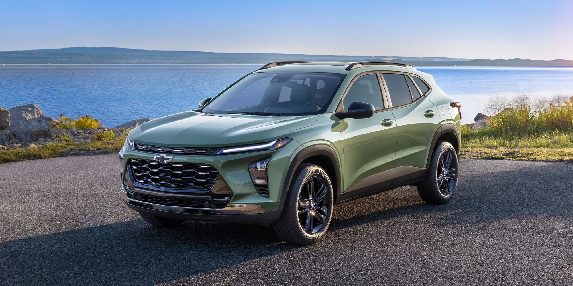 Chevrolet Trax parked on a paved road overlooking a blue lake