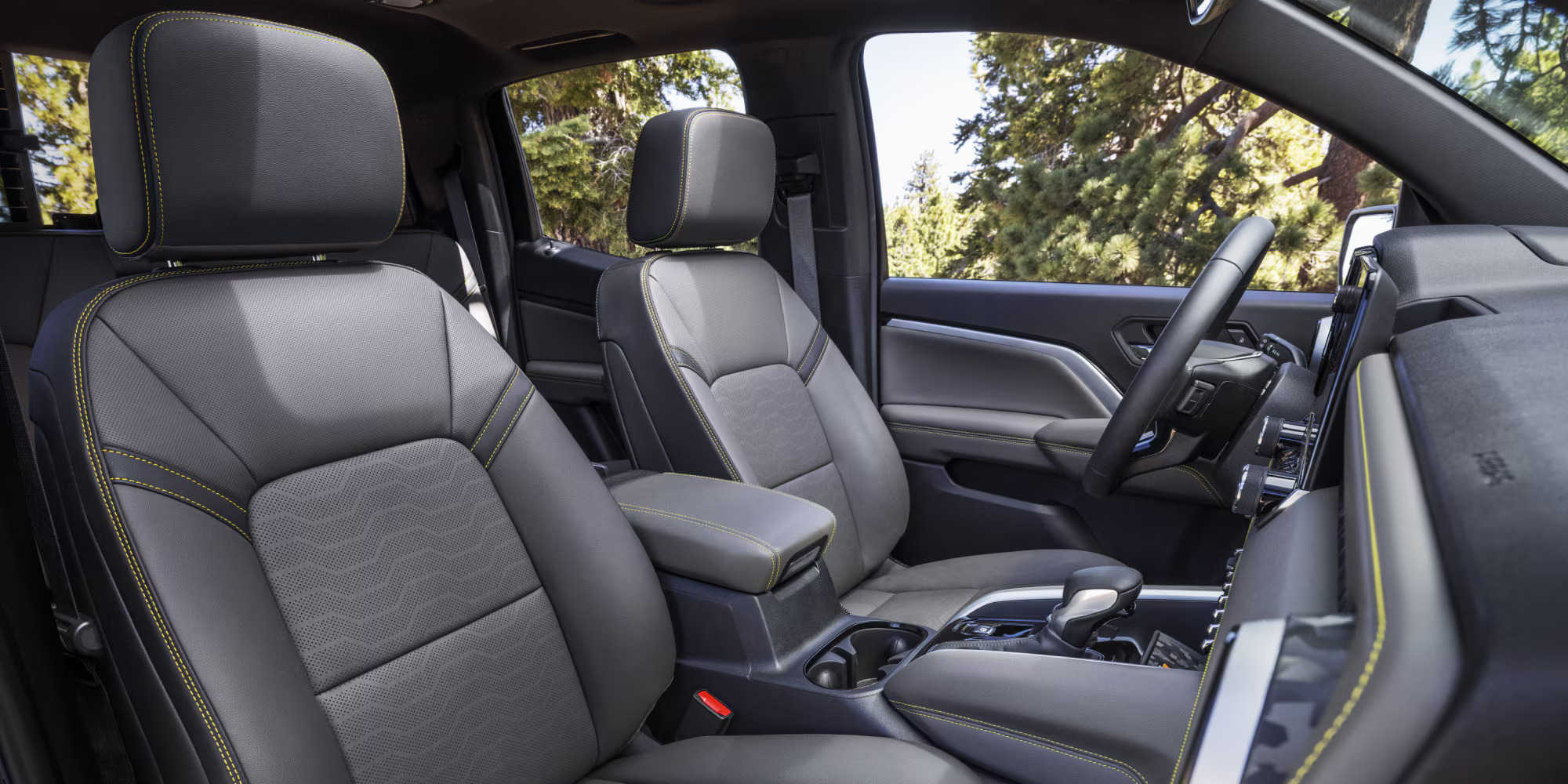 Front interior view of a modern Chevrolet Colorado featuring dark seats with contrast stitching.