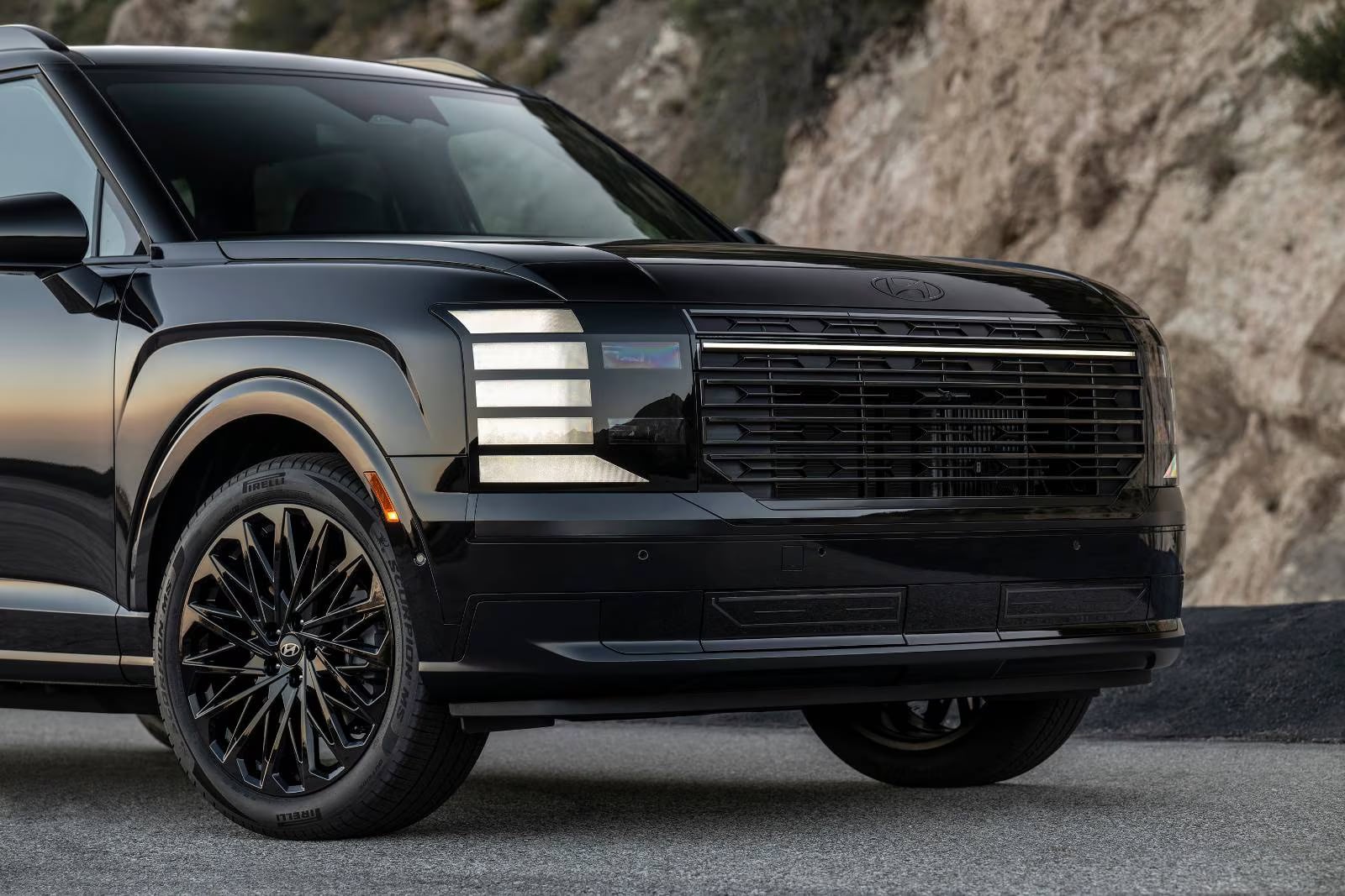 Front view of a glossy black 2026 Hyundai Palisade featuring stacked LED lighting, a dark grille, and alloy wheels.