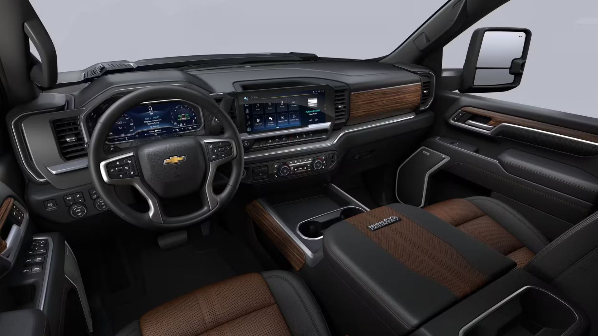 2026 Chevrolet Silverado 3500 HD High Country truck interior with black leather and brown woodgrain accents.
