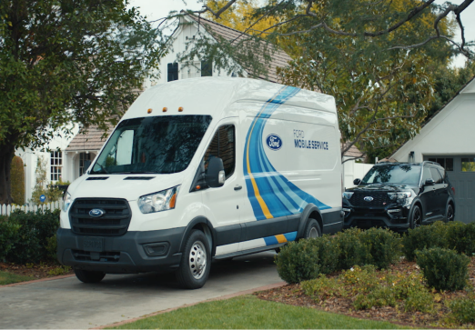A white Ford Mobile Service van parked in a driveway next to a black Ford SUV.